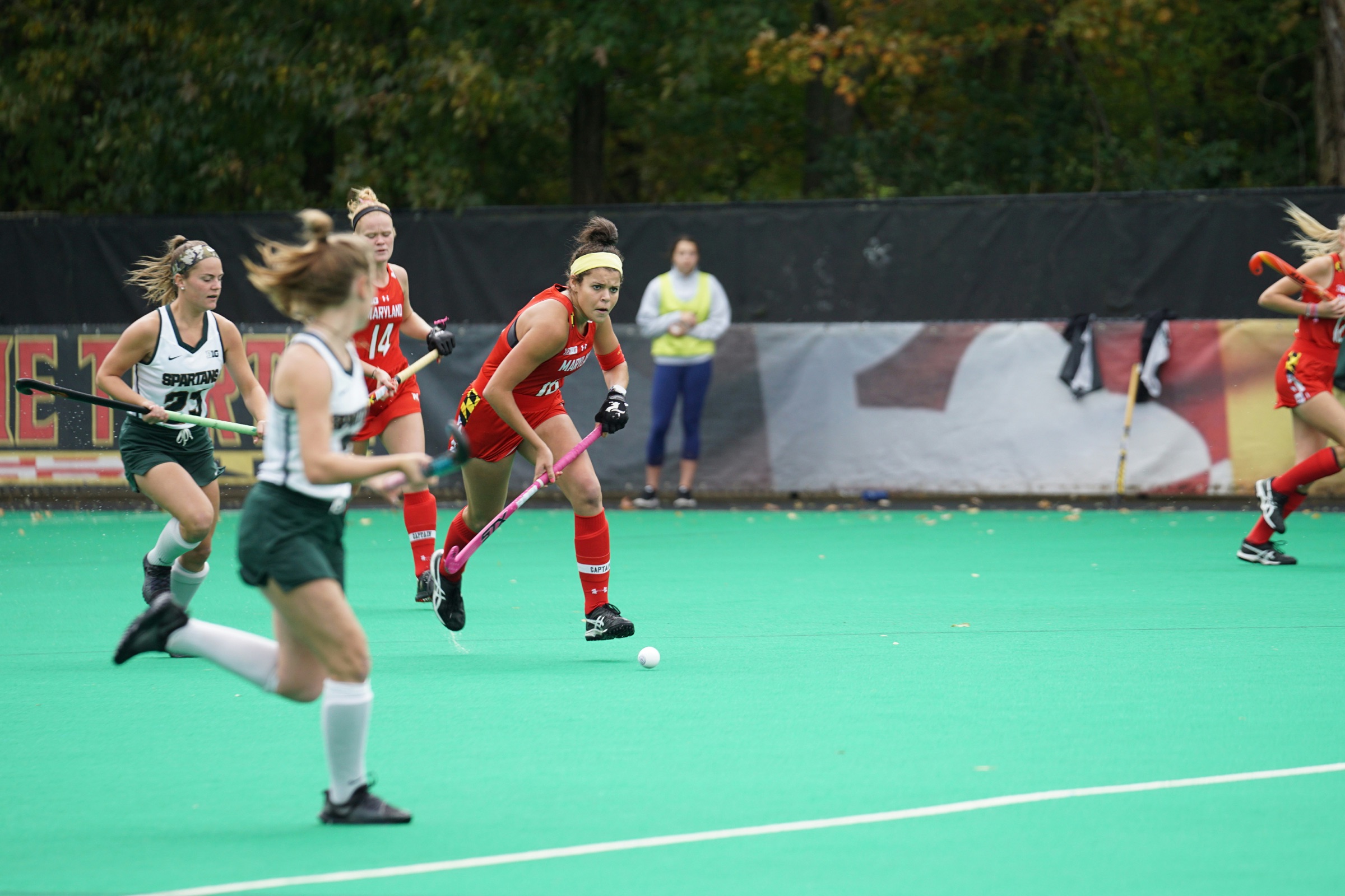 Women's field hockey game on a green turf field during competitive play